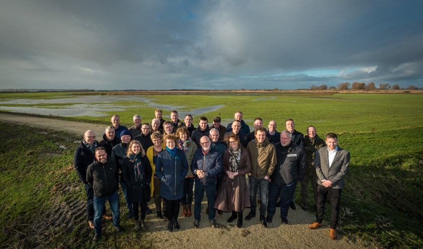 Delegatie Flevoland groepsfoto: een foto van de delegatie, met op de achtergrond de Zuiderdieppolder.
