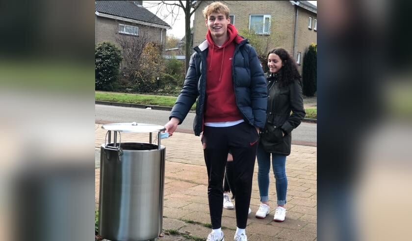 Een leerling van het Marne College deponeert zijn mondkapje in een afvalbak.