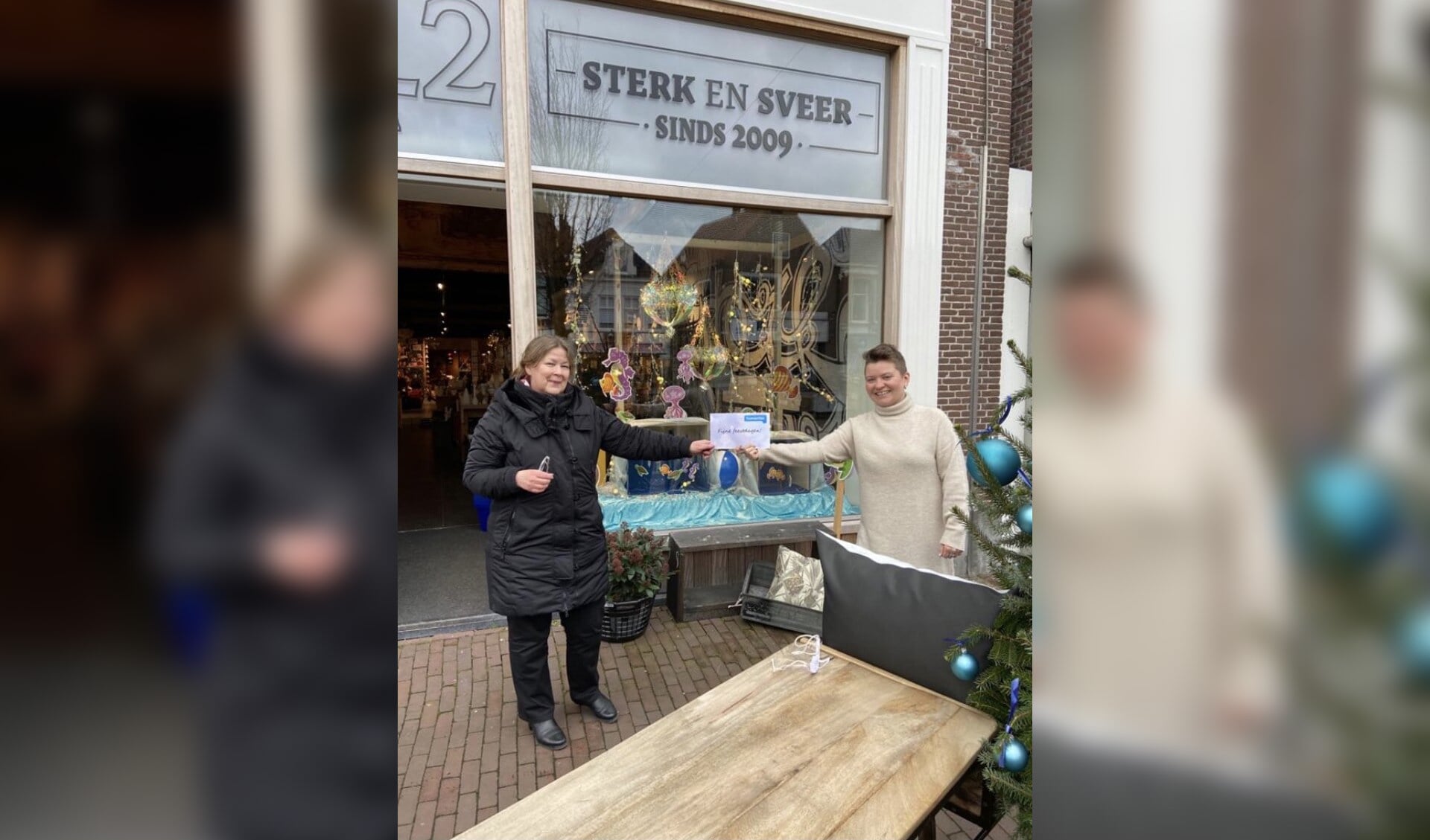 Josée Peereboom van Humanitas Zuidwest Friesland (links) ontvangt de cadeaubonnen van Piety van der Veer van Sterk en Sveer.
