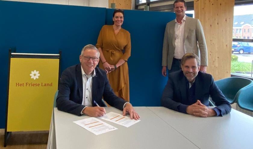 Klaas Kuilman, directeur van Thuiszorg Het Friese Land (zittend links), en Erik Wijnhof, directeur van Zorgcentrale Noord (zittend rechts) ondertekenen het nieuw contract, Ypie Duursma-Groenewoud van Thuiszorg Het Friese Land en Maarten den Heijer van Zorgcentrale Noord kijken toe.