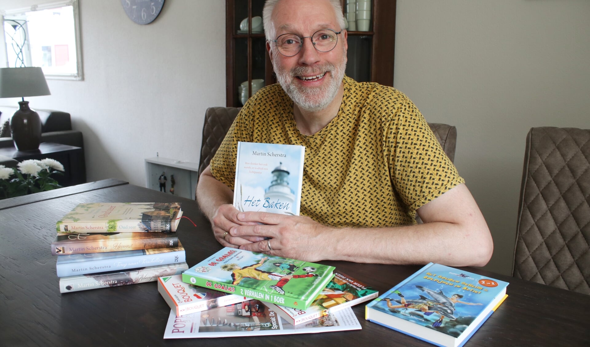 Schrijver Martin Scherstra toont enkele van de boeken die hij heeft geschreven.