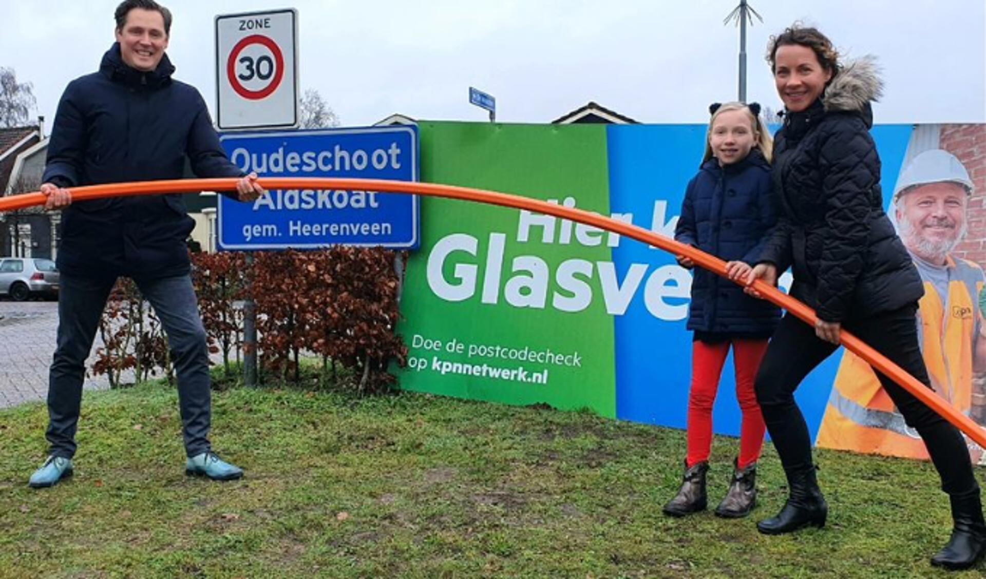 Eeltje Bakker van Plaatselijk Belang en wethouder Rinkes met haar dochter zijn verheugd dat ook Oudeschoot wordt aangesloten op het glasvezelnetwerk van KPN.