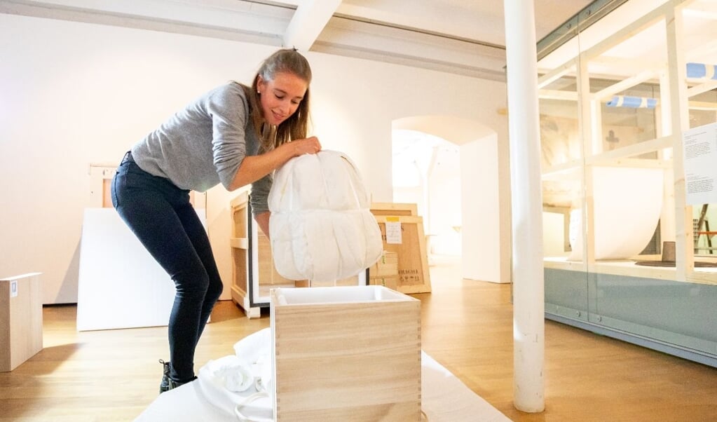 Eline van der Berg, conservator Aziatische keramiek, pakt zorgvuldig de transportkist uit 