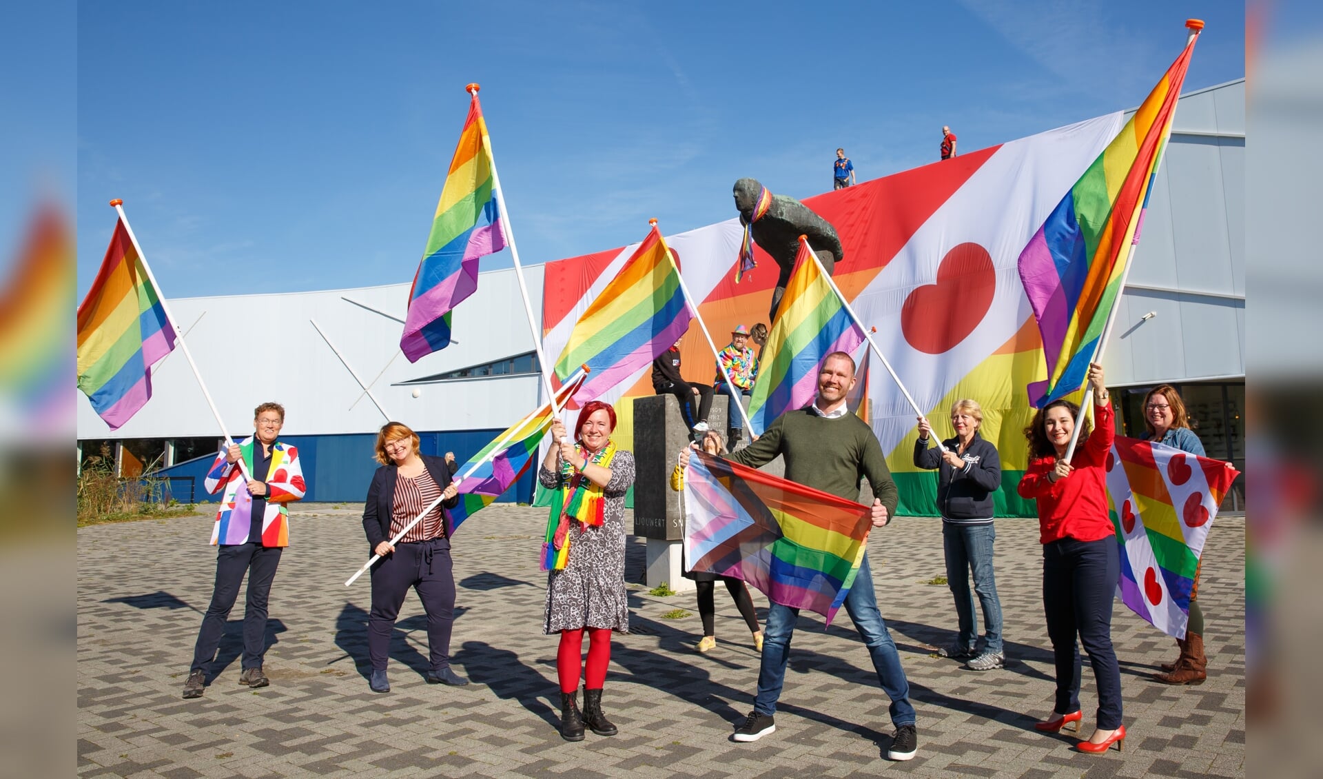 De reuzegrote regenboogvlag werd uitgerold vanaf het dak van de Elfstedenhal.
