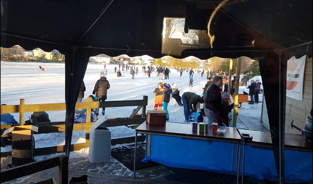 Mooi sfeerbeeld van de drukte op de ijsbaan van Appelscha.