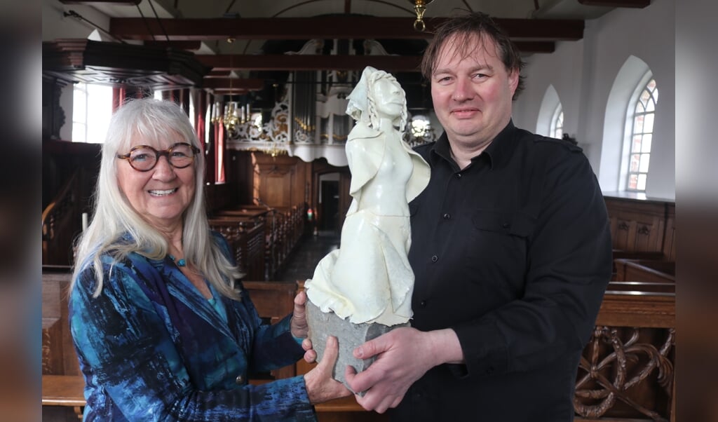 Kunstenares Rian Vis van Heemst overhandigt het beeld van Anna Maria van Schurman aan gids Stephan Kurpershoek.