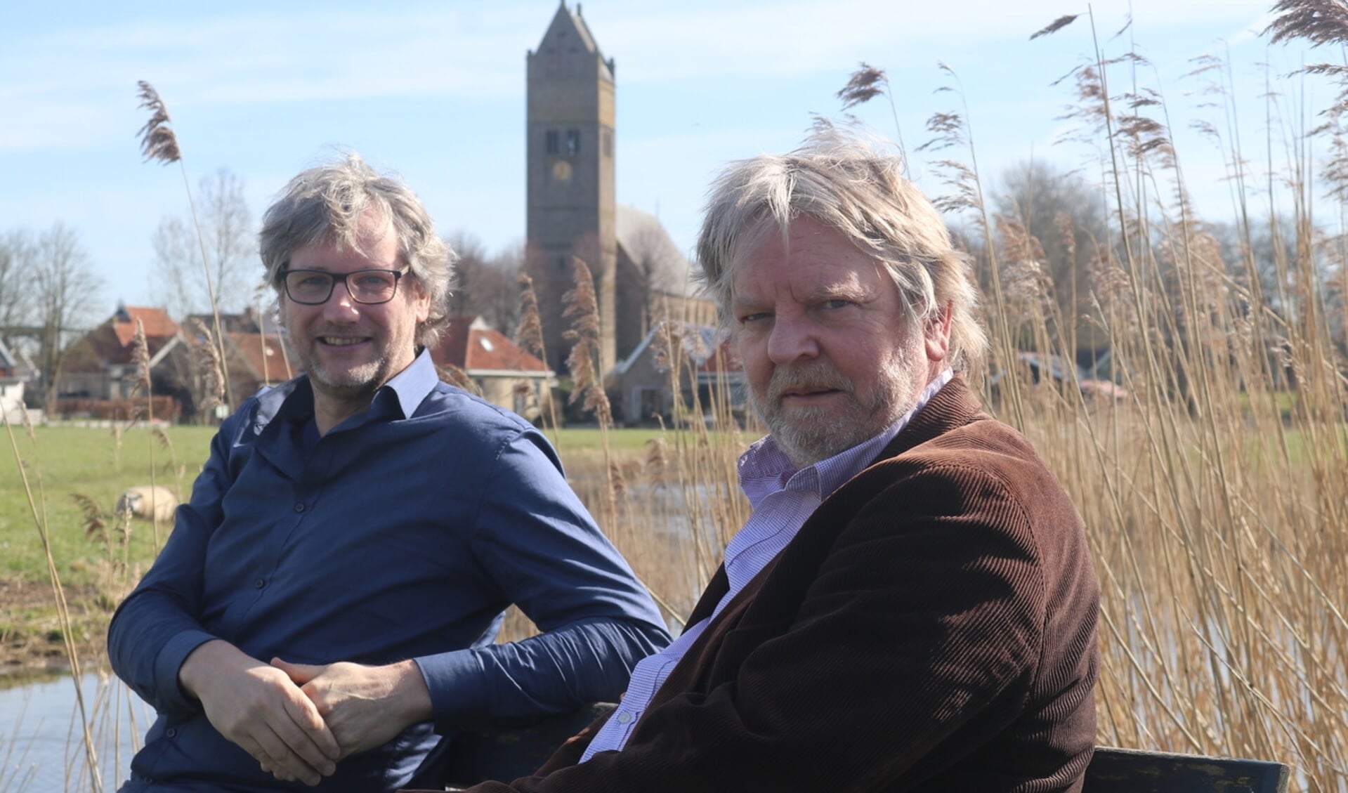 Juryleden Elmar Kuiper (links) en Abe de Vries genieten van het mooie weer aan de rand van Jorwert, het bijzondere dorp in de Friese Greidhoeke. Met veel aandacht hebben ze de tientallen gedichten beoordeeld.