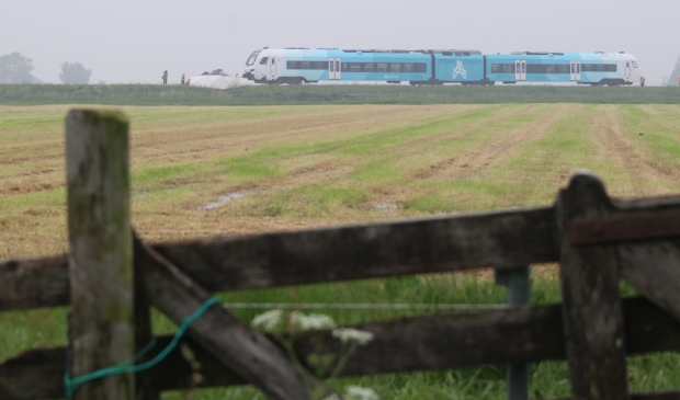 <p>De trein, vanuit Boazum gefotografeerd. Het witte doek is door de brandweer om de kapotte auto gespannen zodat de privacy gewaarborgd is van de twee omgekomen personen.</p>
