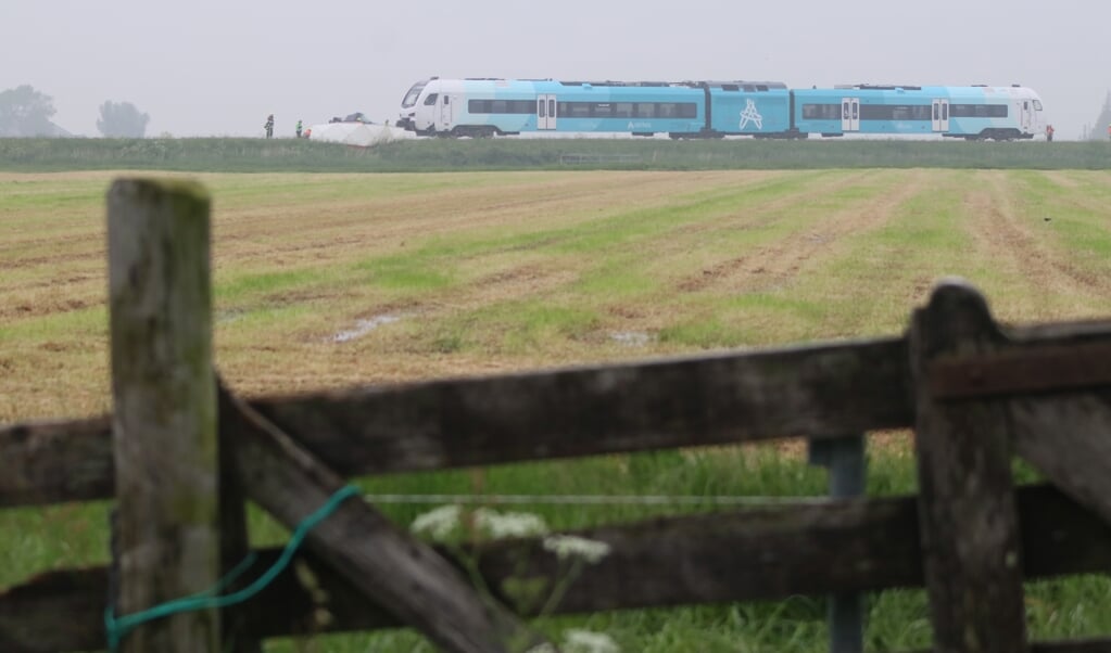 De trein, vanuit Boazum gefotografeerd. Het witte doek is door de brandweer om de kapotte auto gespannen zodat de privacy gewaarborgd is van de twee omgekomen personen.