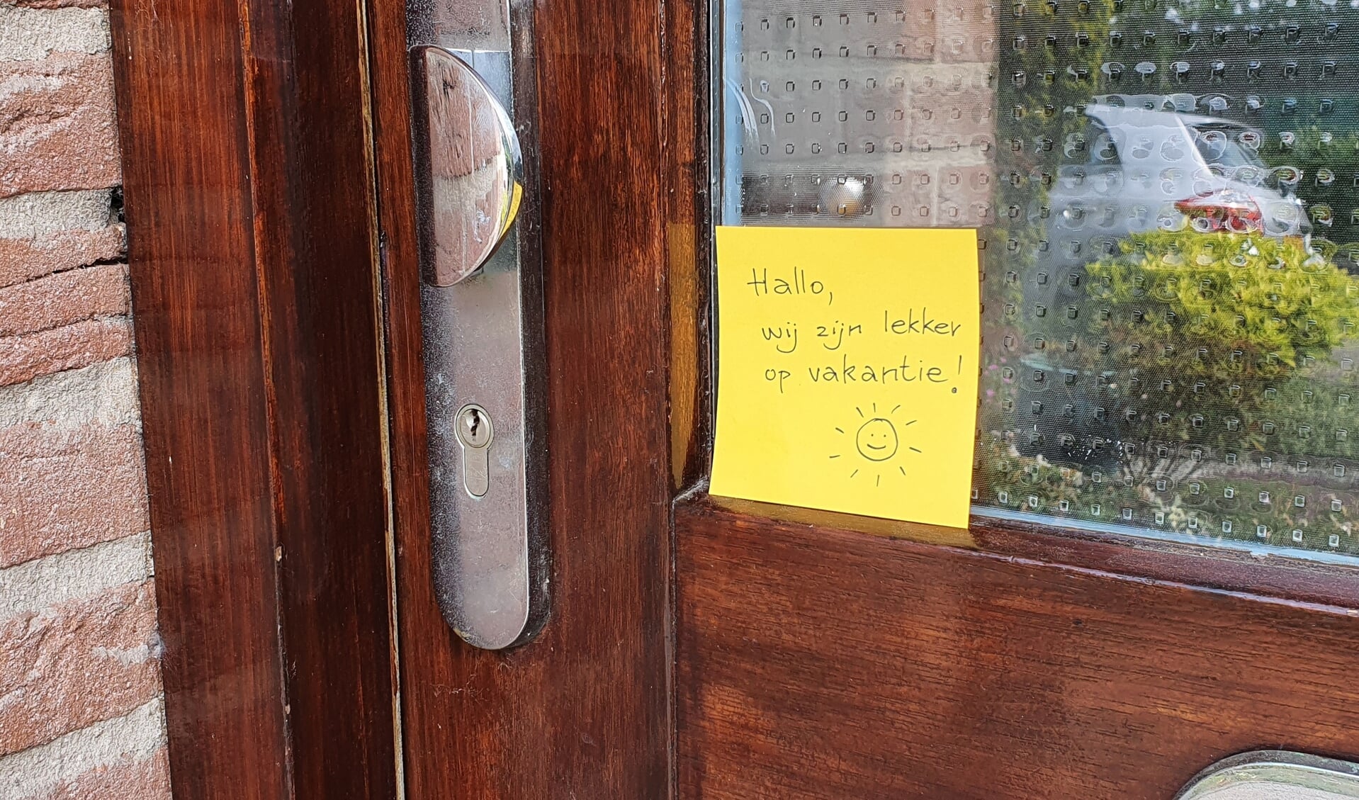 Briefje op voordeur 'Hallo, wij zijn lekker op vakantie!'