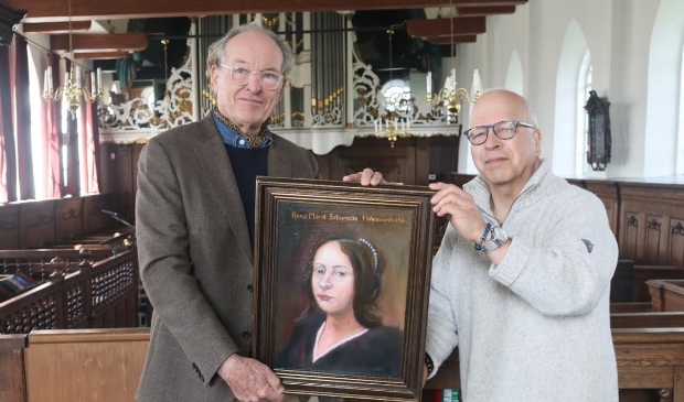 <p>Arthur Oster (links) reikt het schilderij uit aan Henny Boon von Ochsee, die de kerk van Wiuwert vertegenwoordigd.</p>