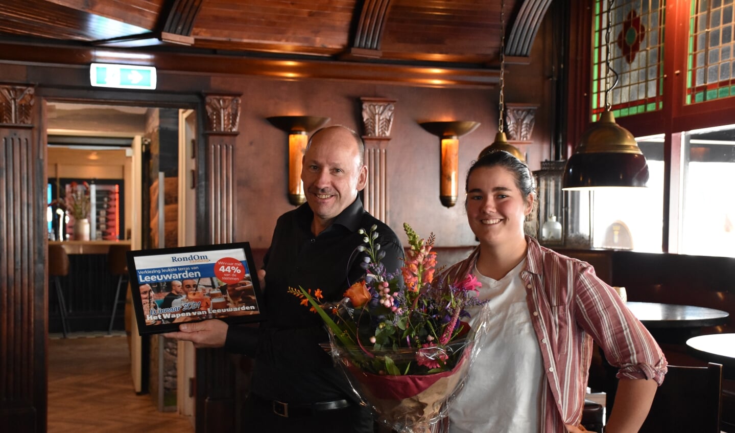 Herman van Cleef, een van de eigenaren van het Wapen, neemt de prijs aan van RondOm redacteur Melissa Wijnja.