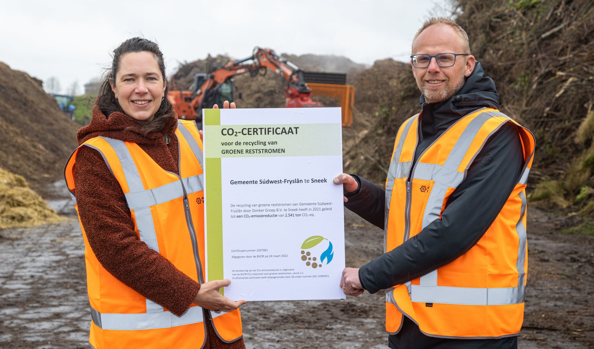 Esther Wierda-Kruiper (manager duurzaamheid en circulariteit) van Donker Substrates reikt het allereerste CO2-certificaat voor de recycling van groene reststromen uit aan Hein Quarré (manager Schoon) van de gemeente Súdwest-Fryslân. 