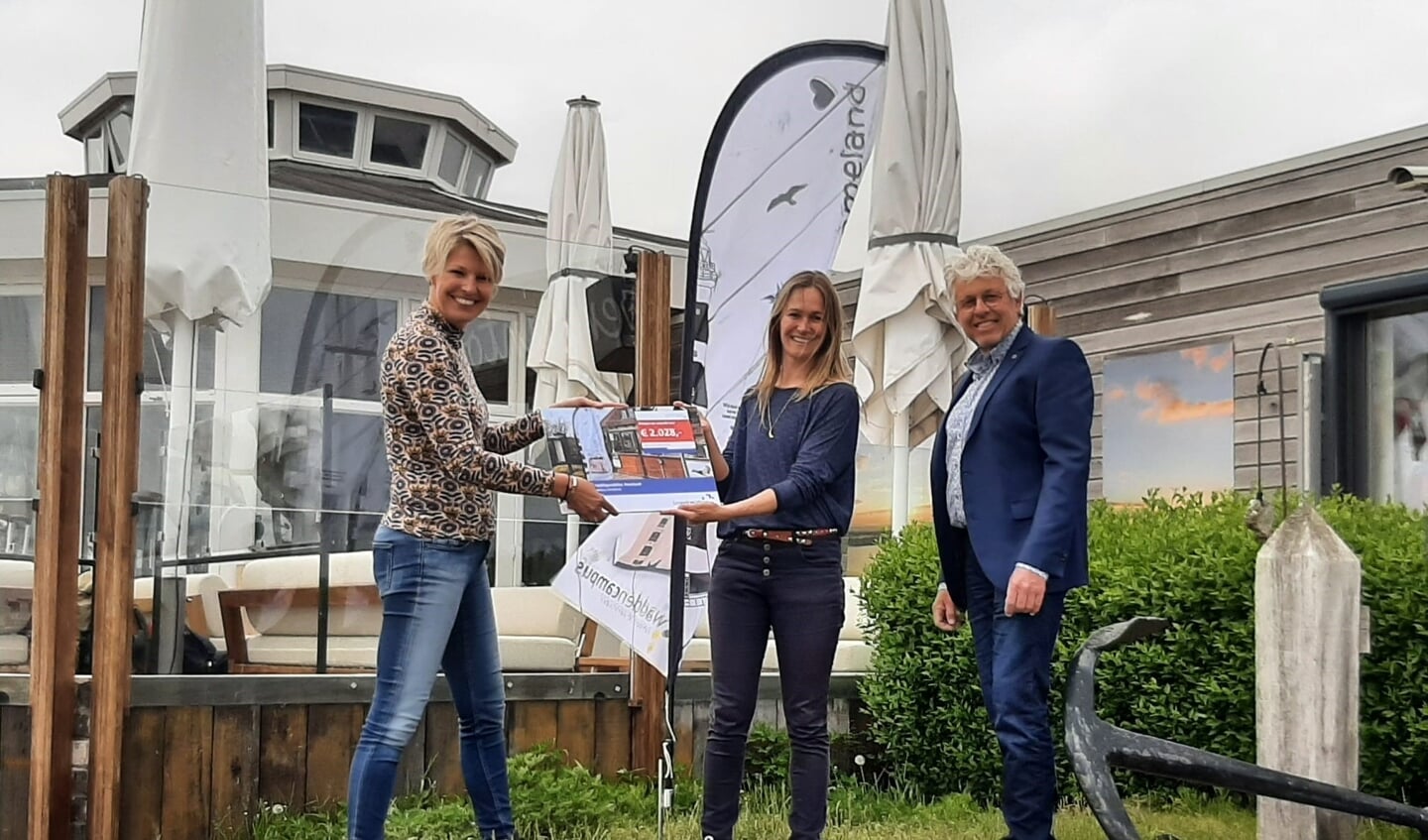 Marieke Ferwerda, opgaveregisseur bij provincie Fryslân, overhandigt de cheque van 2028 euro aan Esther Oud en Ruud Kramer van Stichting Waddencampus Ameland.