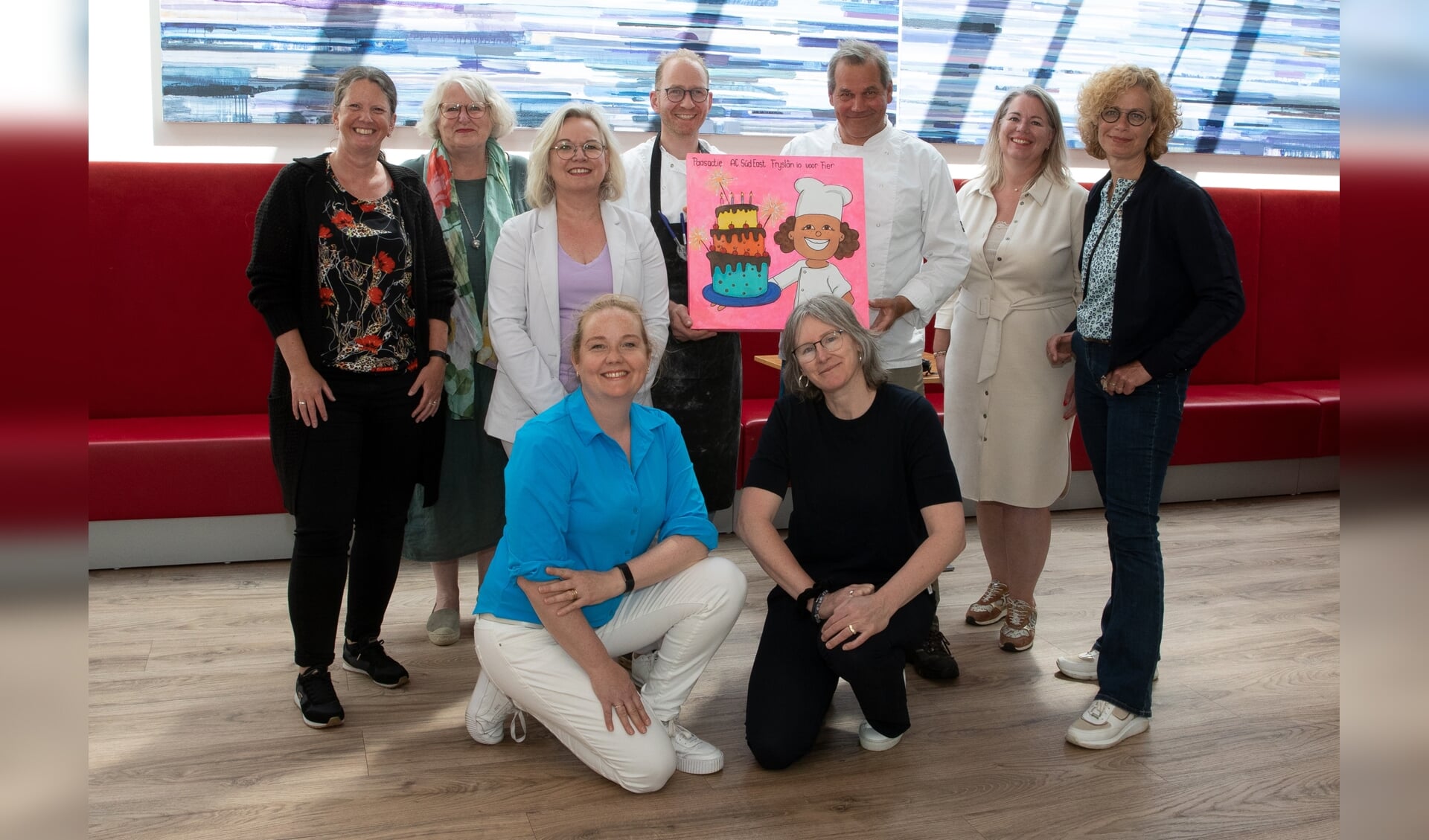 Leden van Agora Club Súd East Fryslân i.o. overhandigen het bedrag van de paasactie, verstopt in de taart en de bakkersmuts, aan de Blooming Bakery-bakkers Ynse de Boer en Henk Markus.