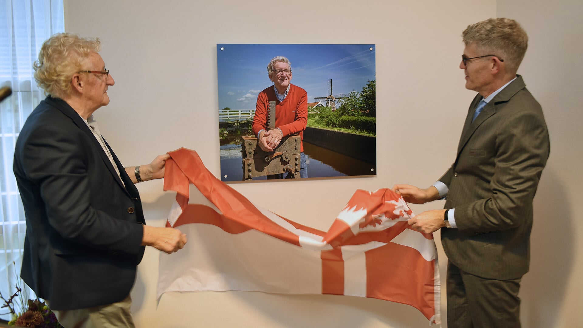 Ereburger Johan Veenstra onthult samen met burgemeester André van de Nadort zijn portret in de galerij ereburgers van gemeente Weststellingwerf.