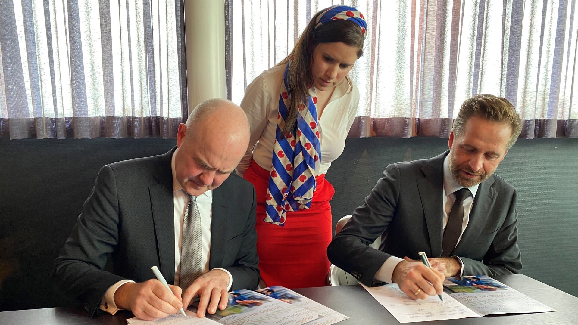 De ondertekening door minister Hugo de Jonge (rechts) en Commissaris Arno Brok (links). In het midden Eke Folkerts.