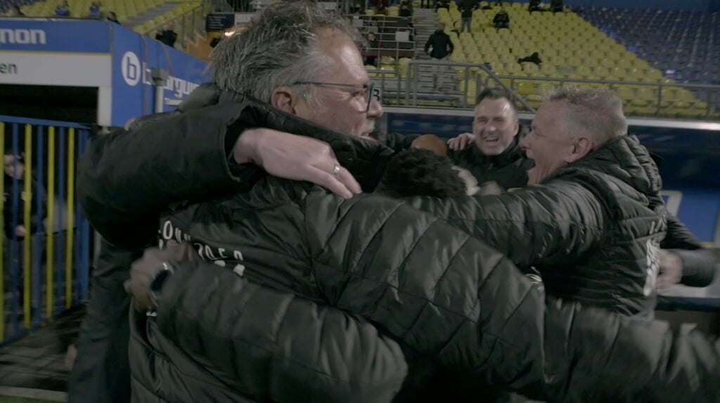 Henk de Jong juichend met zijn staf, na de wedstrijd tegen Helmond Sport die de promotie van SC Cambuur bezegelt.