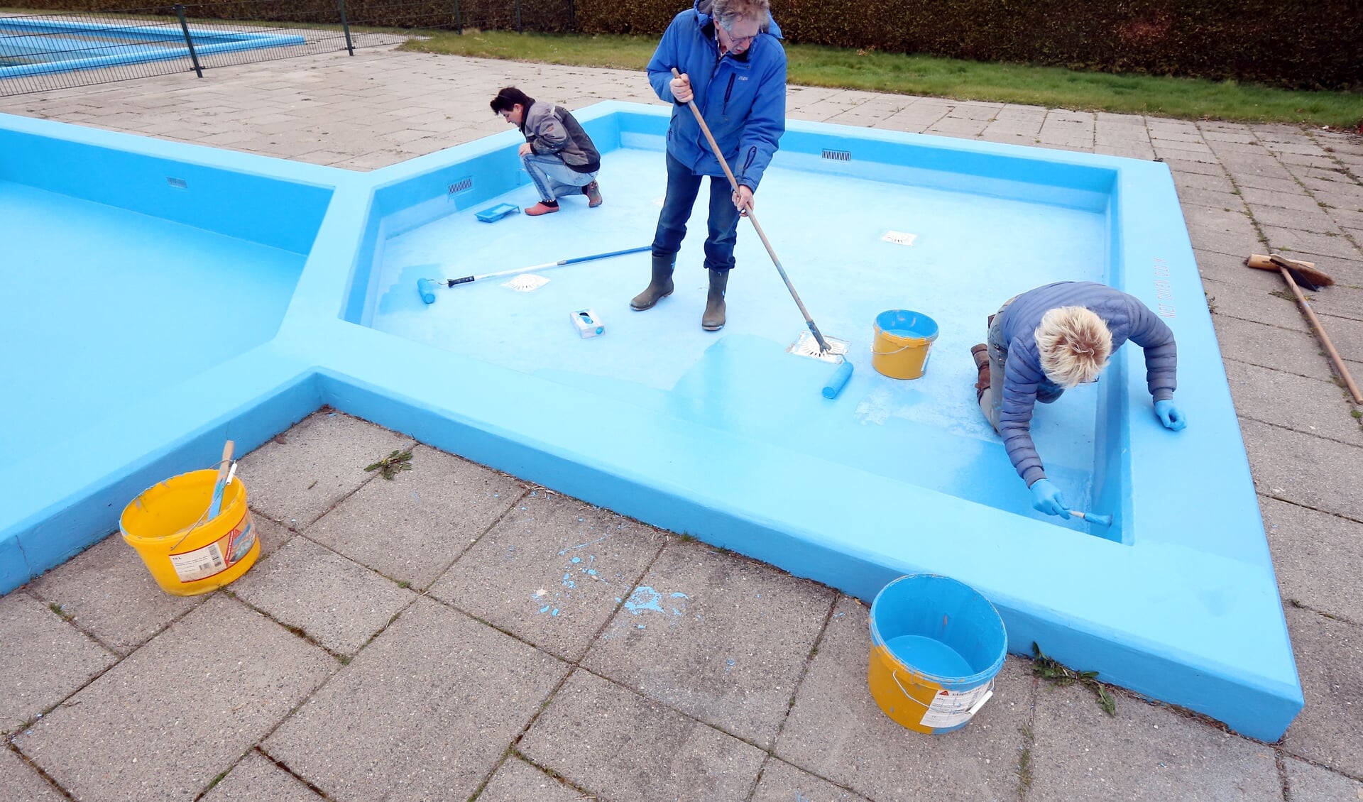 Vrijwilligers verven het peuterbad van De Blauwe Kamp.