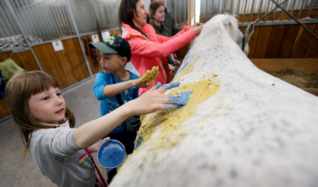 Met stoepkrijt beschilderen de kinderen het lijf van Silvester. 