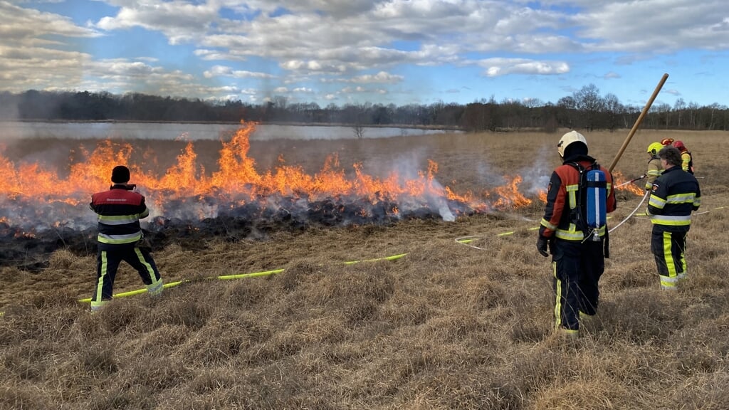 Brandweermannen houden de brand goed in de gaten. 