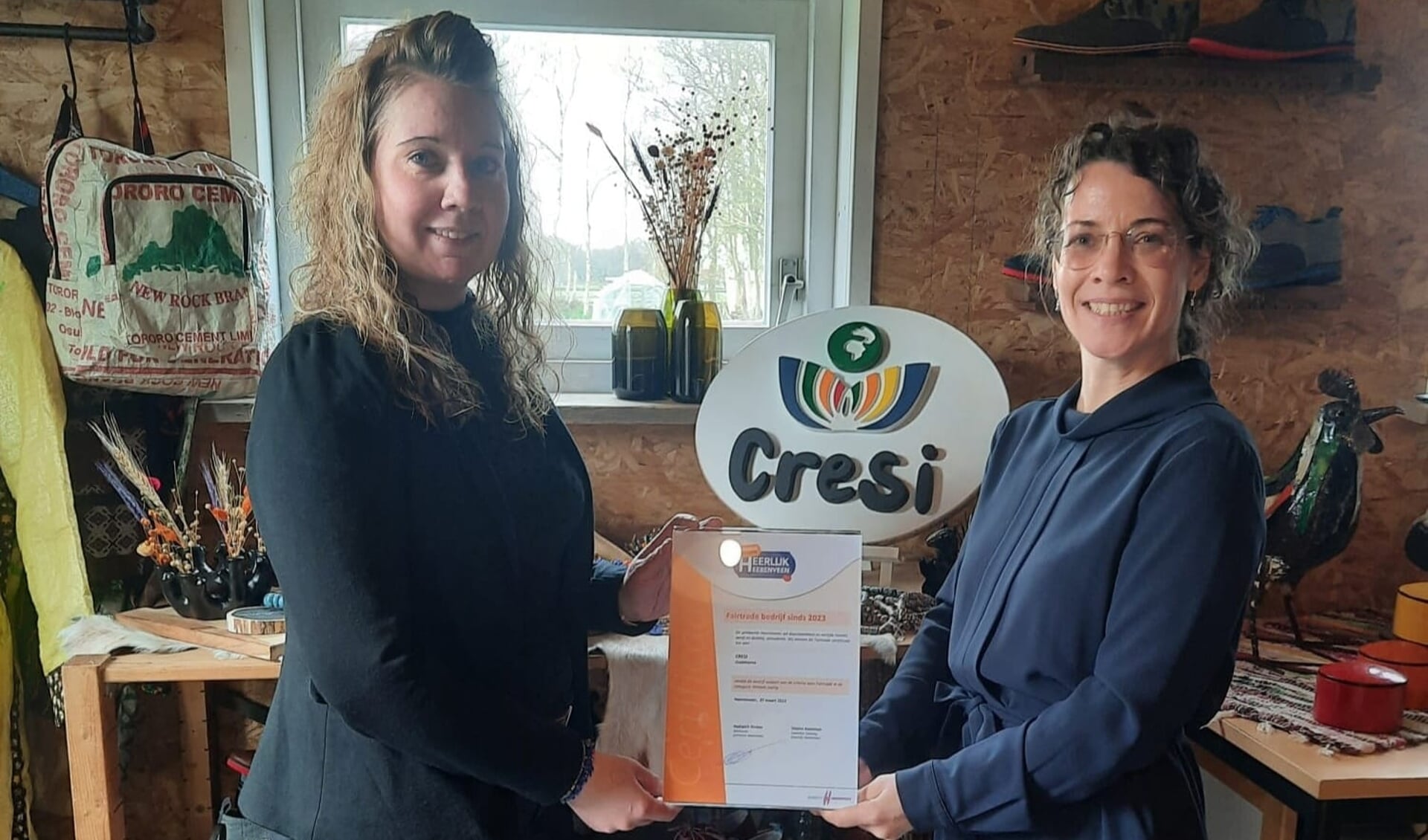 Wethouder Hedwich Rinkes reikt Fairtrade certificaat uit aan Marianne Pen, eigenaresse Cresi.
