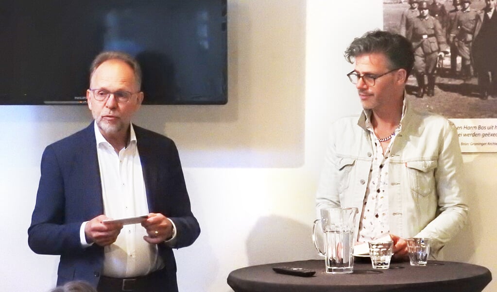 Wethouder Libbe de Vries en tv-maker Erik Dijkstra. Op de achtergrond de foto van Jan Eisenga op weg naar zijn executie.