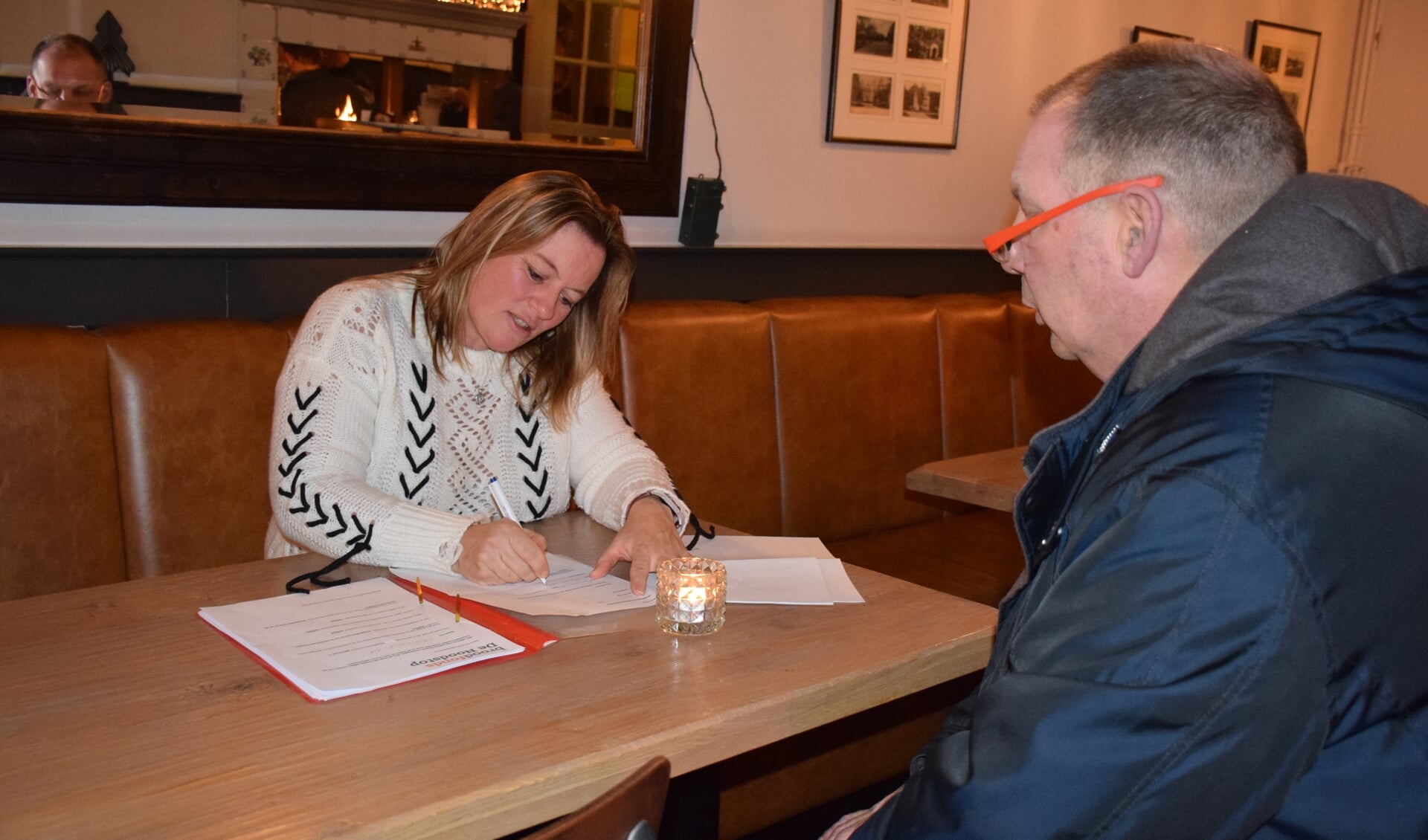 Sandra Konings, van autorijschool Konings in Apeldoorn, is voorzitter van het broodfonds. Hier tekent zij een van de contracten. 