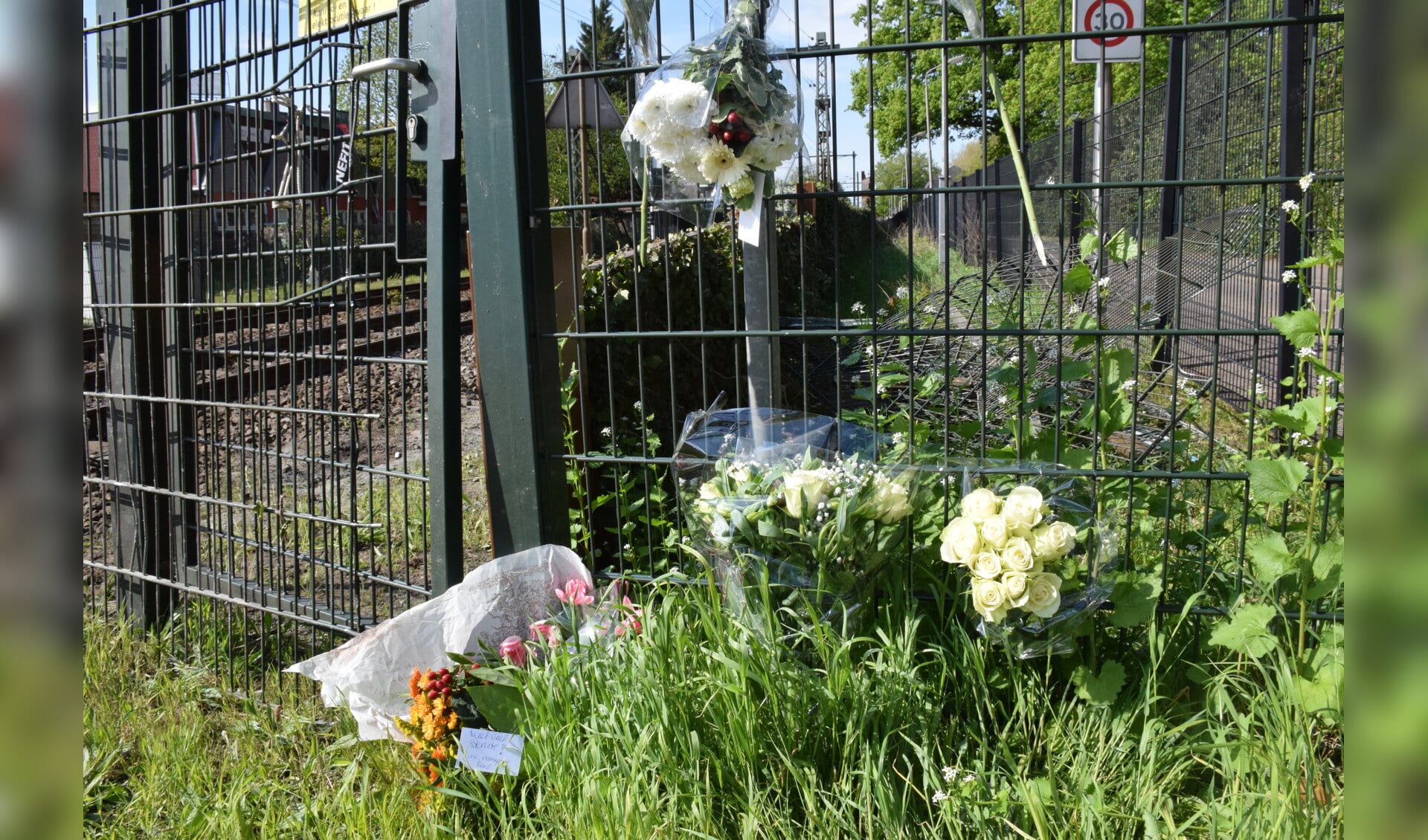 Op de spoorwegovergang hebben verschillende mensen bloemen gelegd als eerbetoon aan Henk Reinink.