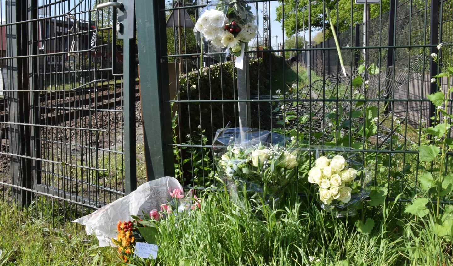 Bij de spoorwegovergang hebben verschillende mensen bloemen gelegd als eerbetoon aan Henk Reinink.
