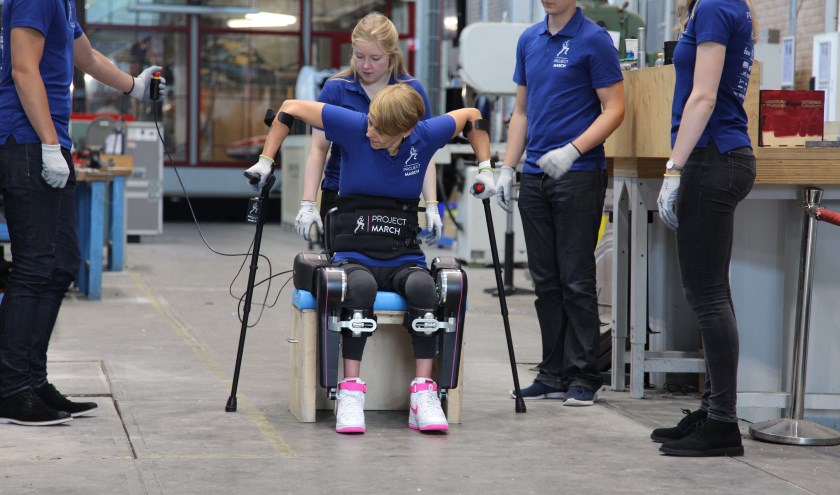 Karlijn en Sjaan Quirijns, omringd door de rest van het team, in actie met het exoskelet