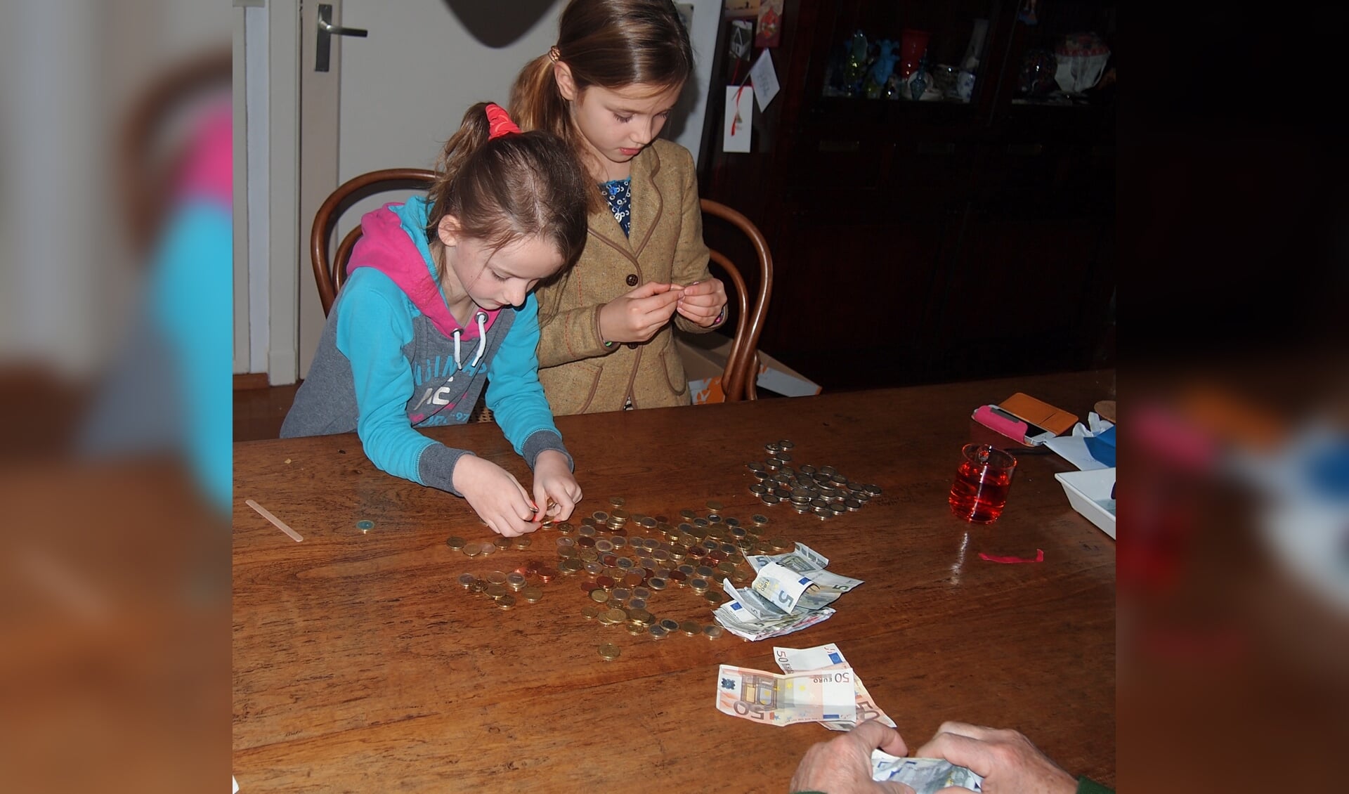 Britt Stam en Imme Schraag tellen het geld dat ze inzamelden voor Bangladesh.