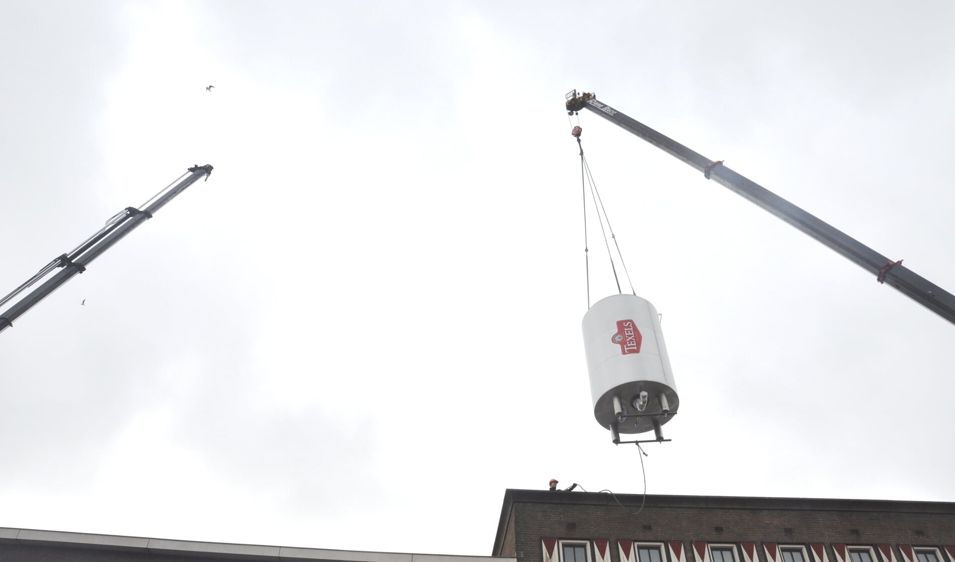 Een van de vier nieuwe tanks hangt boven het dak van de bierbrouwerij.