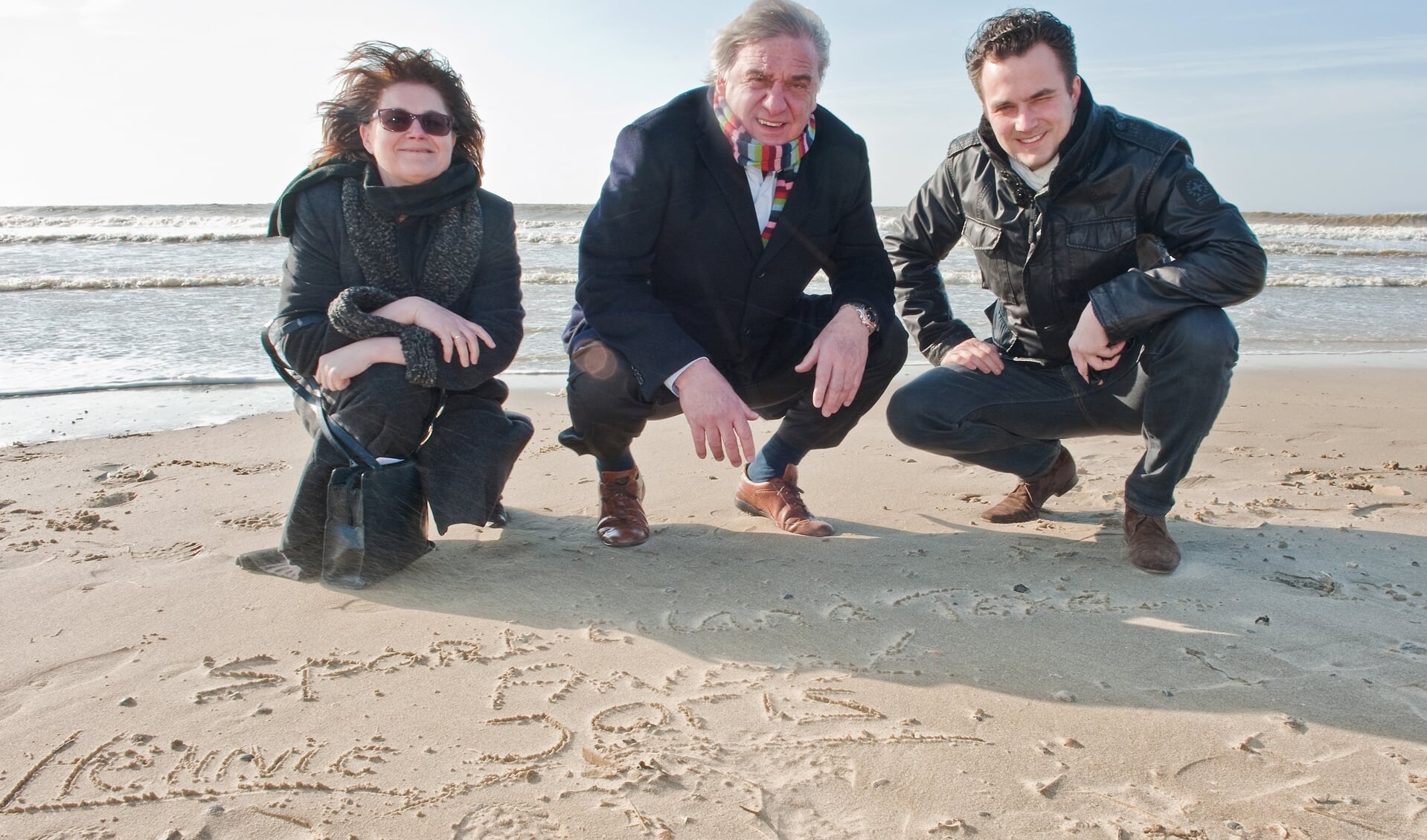 Wethouder Hennie Huisman, NOC*NSF-voorzitter André Bolhuis en ambassadeur Joris Putman schreven hun namen en de woorden Sportweek Texel in het zand. (Foto Gemeente Texel)