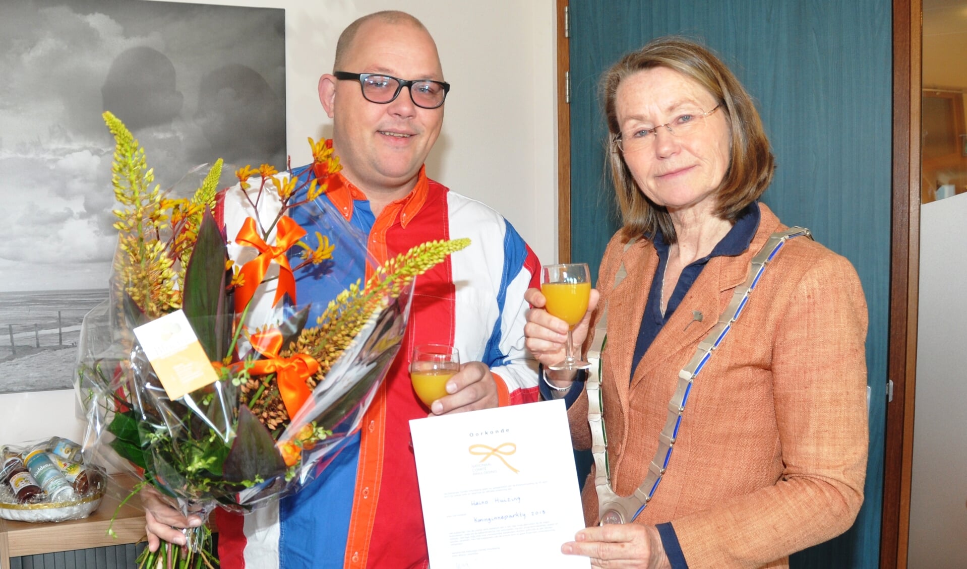 Heino Huizing kreeg van burgemeester Francine Giskes een oranje strik.