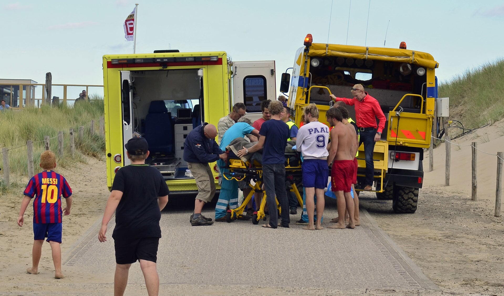 Het slachtoffer wordt overgeladen van de wippertruck van de KNRM in de ambulance. (Foto Marcel Winter/Texelphoto.nl)