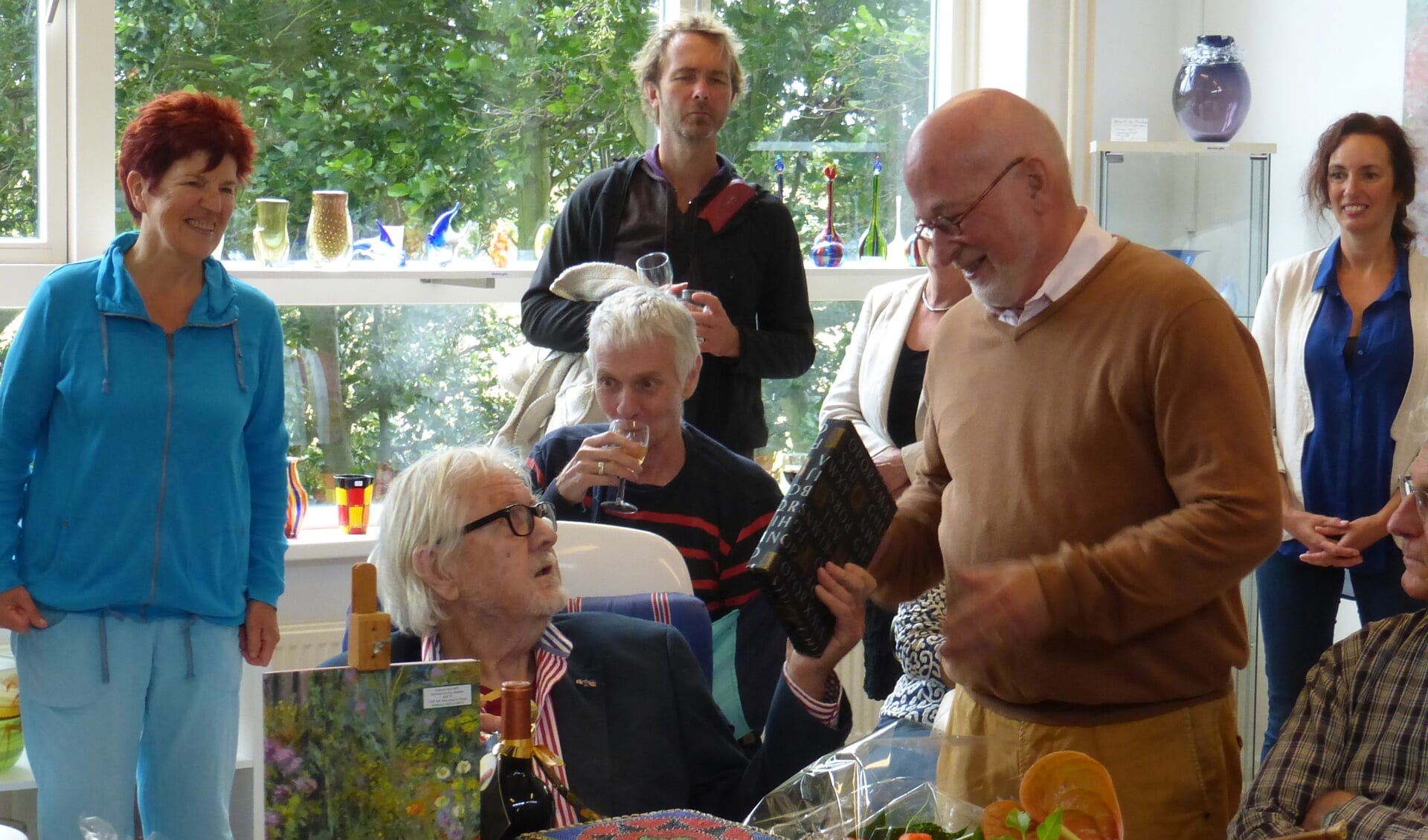 Toon de Haas (zittend), hier vorig jaar, tijdens de tentoonstelling in 't Drijverhuus, toen hij van Herman Bakker een boek ontving. 
