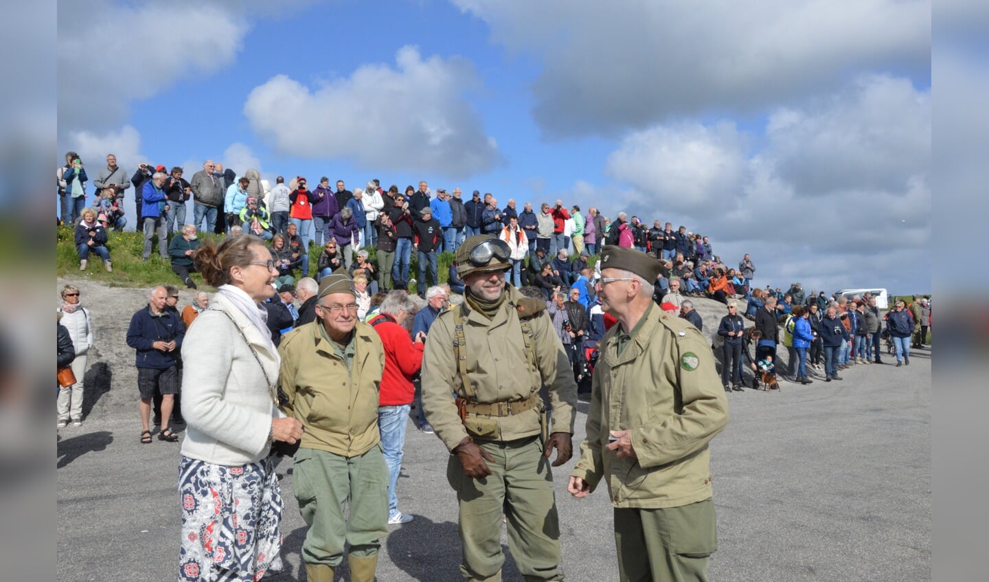 Burgemeester Giskes wacht met mensen van de historische legervoertuigen op het landingsvaartuig. 