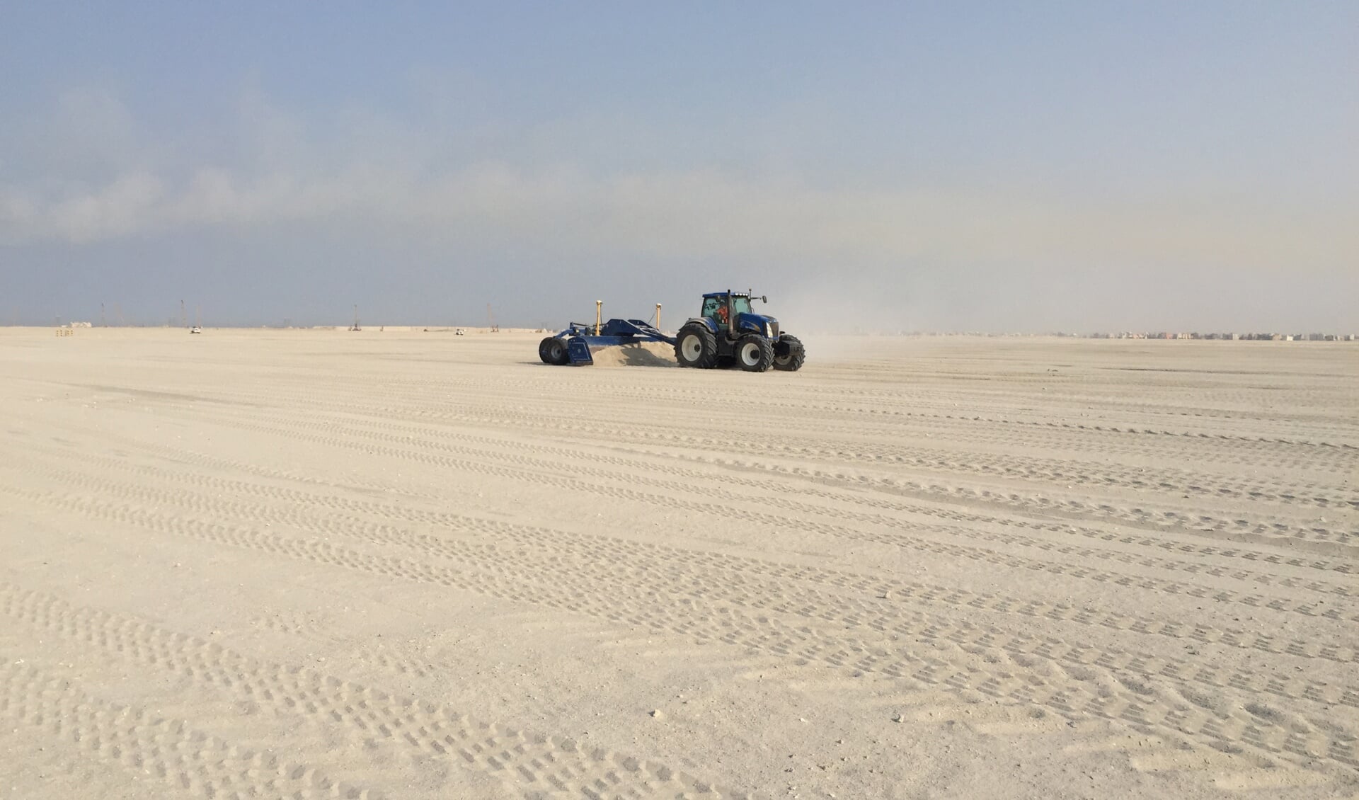 De kilver van het Texelse loonbedrijf firma Duinker egaliseert een zandvlakte in Koeweit. (Foto Firma Duinker)