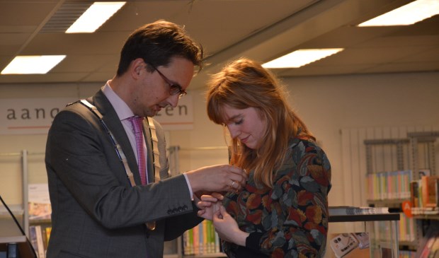 Mare van der Mast krijgt haar broche opgespeld door Burgemeester Uitdehaag.