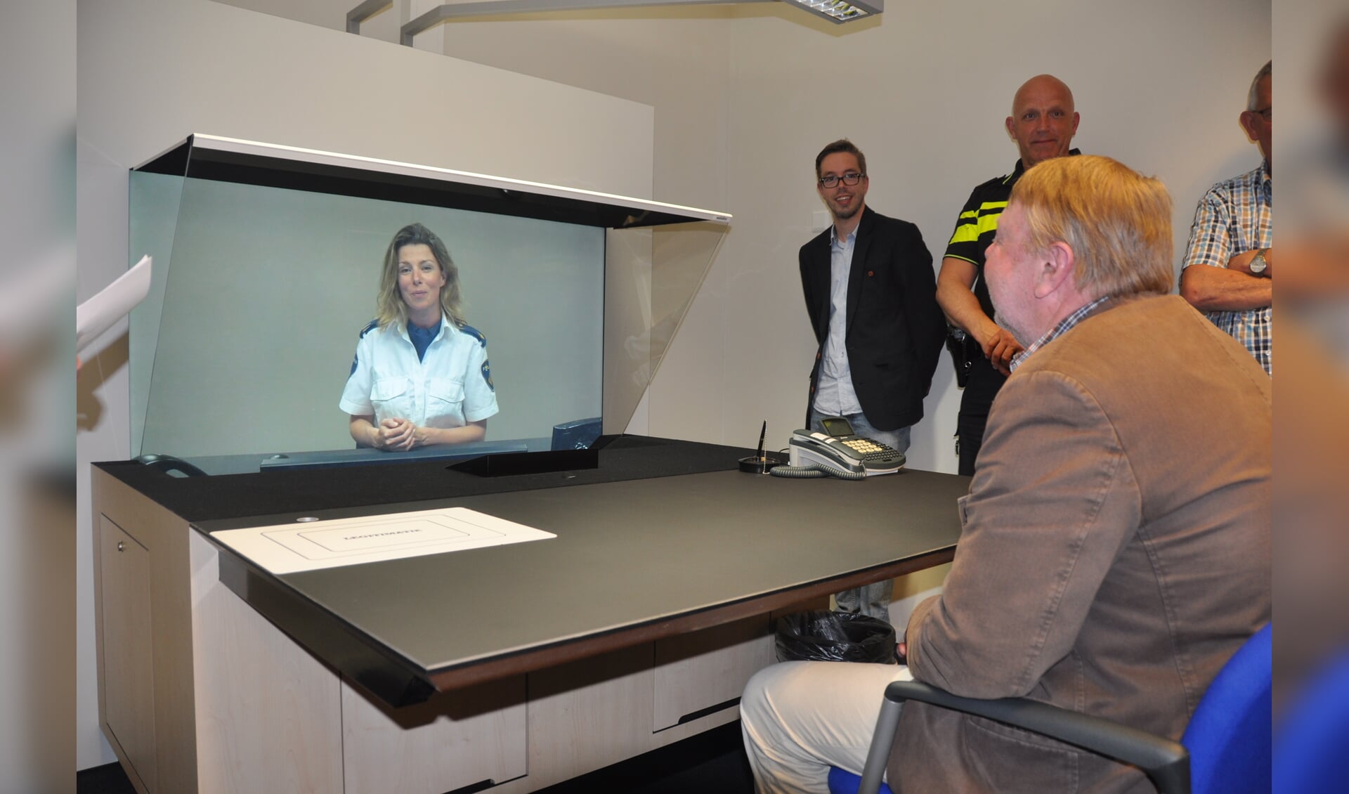 Het nieuwe 3D-loket van de politie in Den Burg. De medewerkster op het scherm bevindt zich in Alkmaar. 