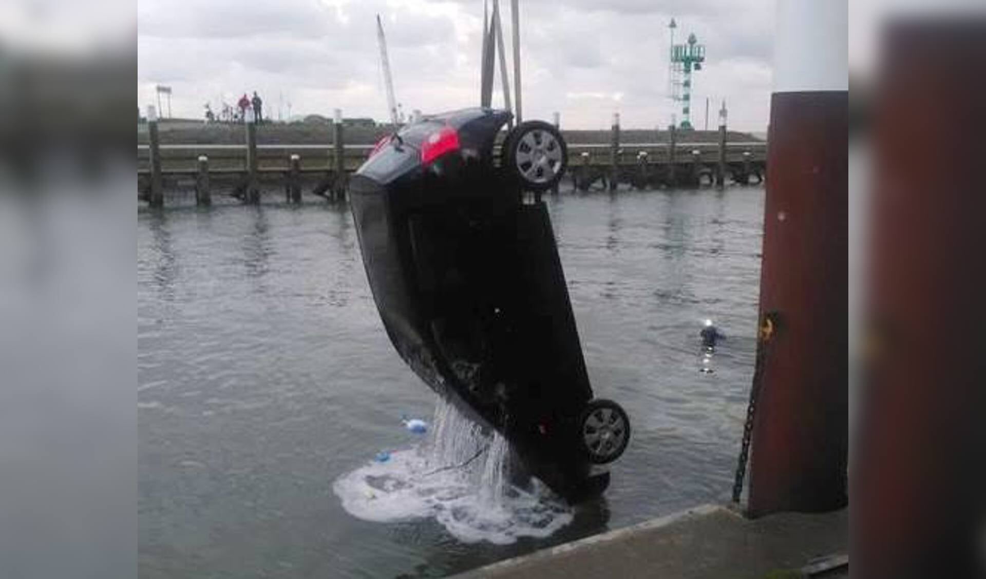 De auto wordt uit de haven gehaald.