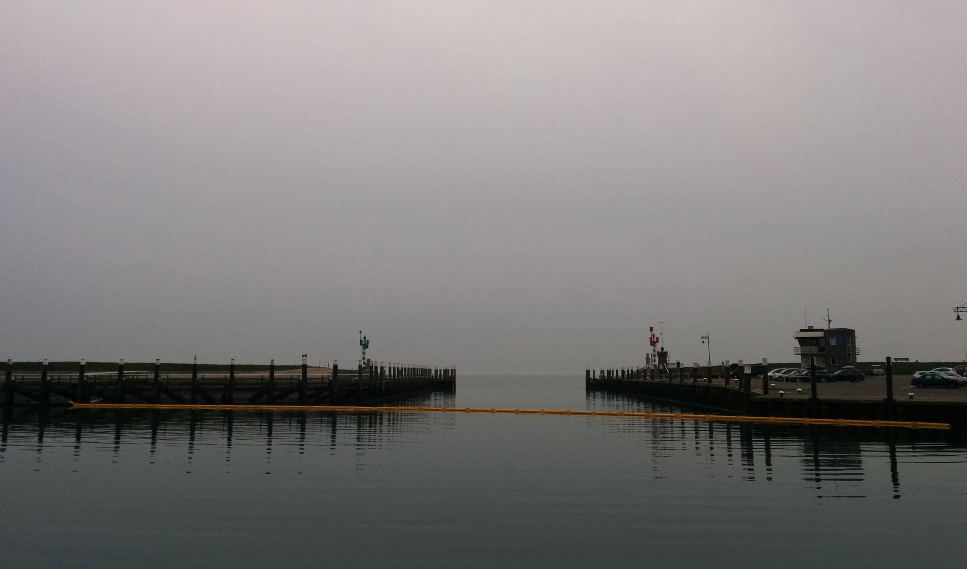 De haven van Oudeschild is nu afgesloten met een geel scherm.