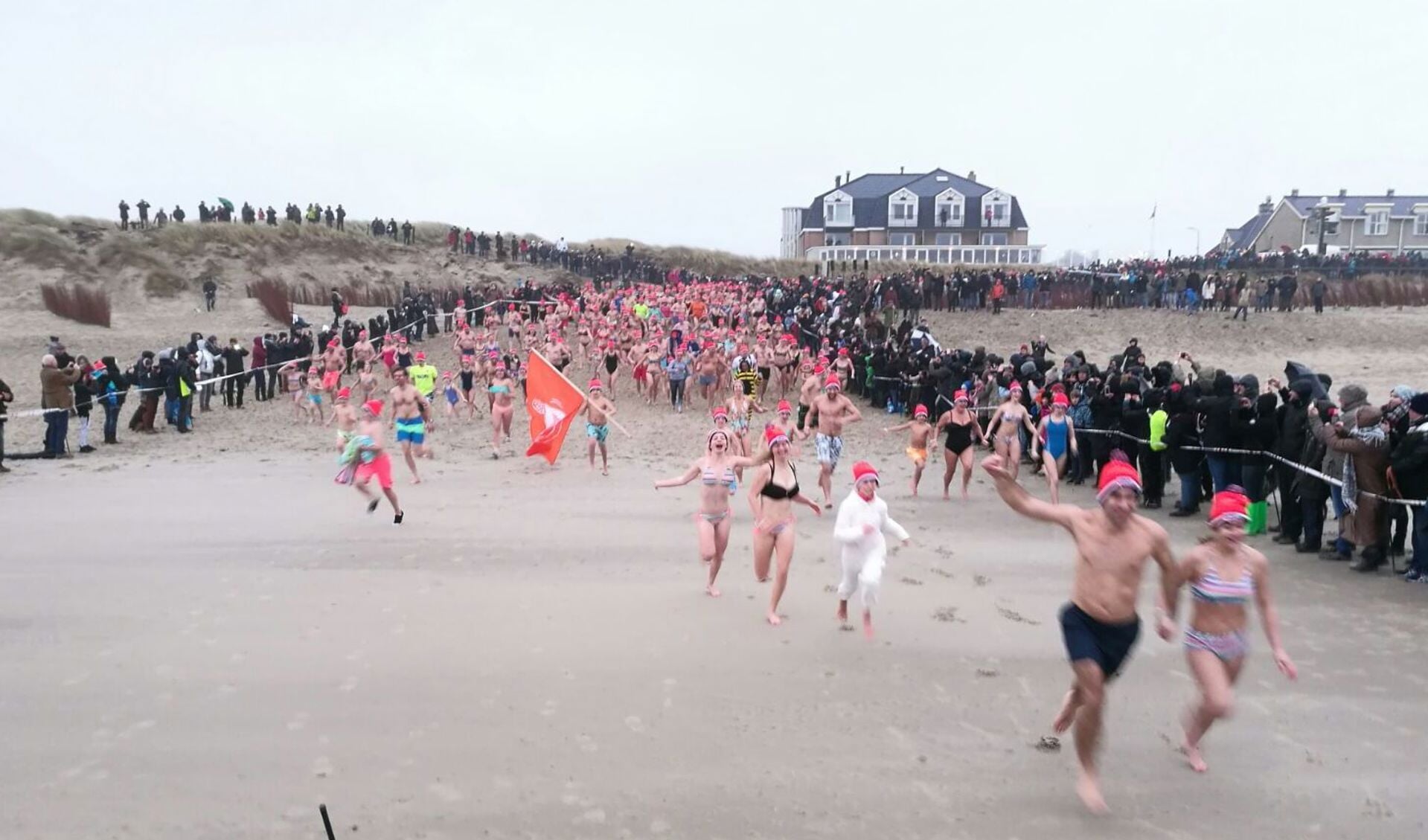 Nieuwjaarduikers rennen in De Koog naar zee. 
(Foto Job Schepers)