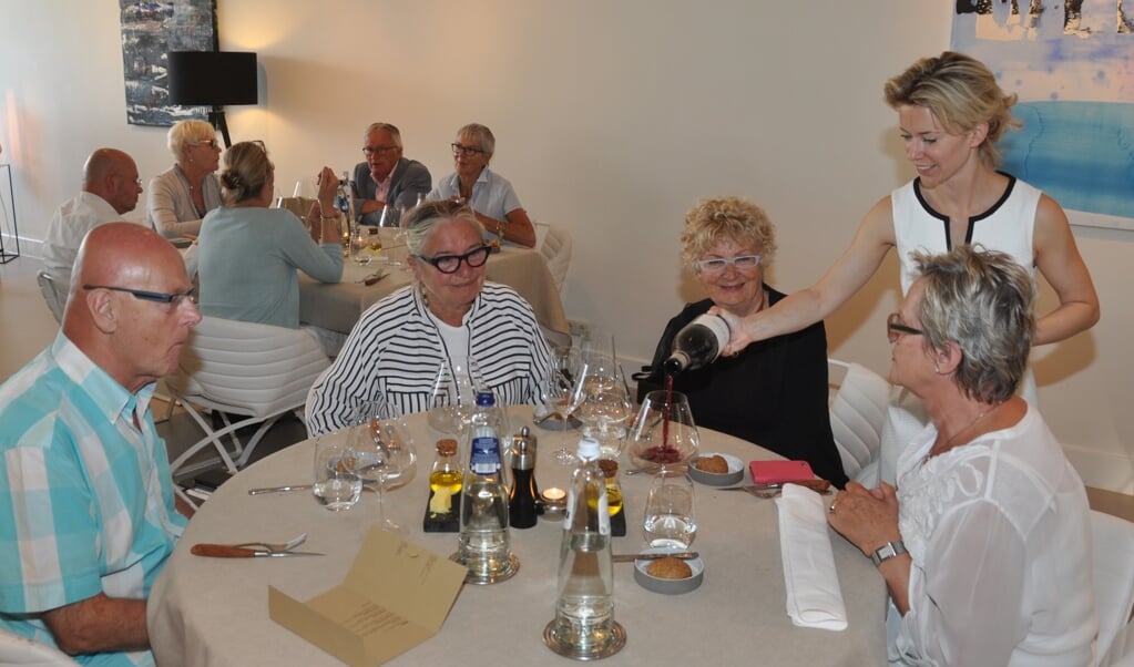Nadine Mögling schenkt wijn in bij gasten van het restaurant.