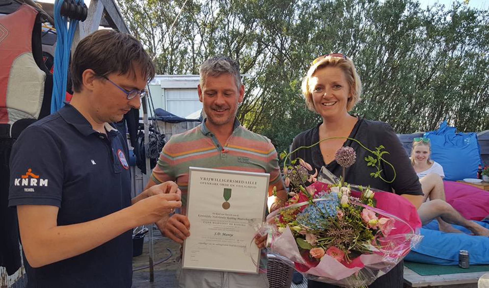 Burgemeester Michiel Uitdehaag, tevens voorzitter van de Plaatselijke commissie KNRM Texel, overhandigt Sandor en Jacobine Mantje een oorkonde en bloemen. 