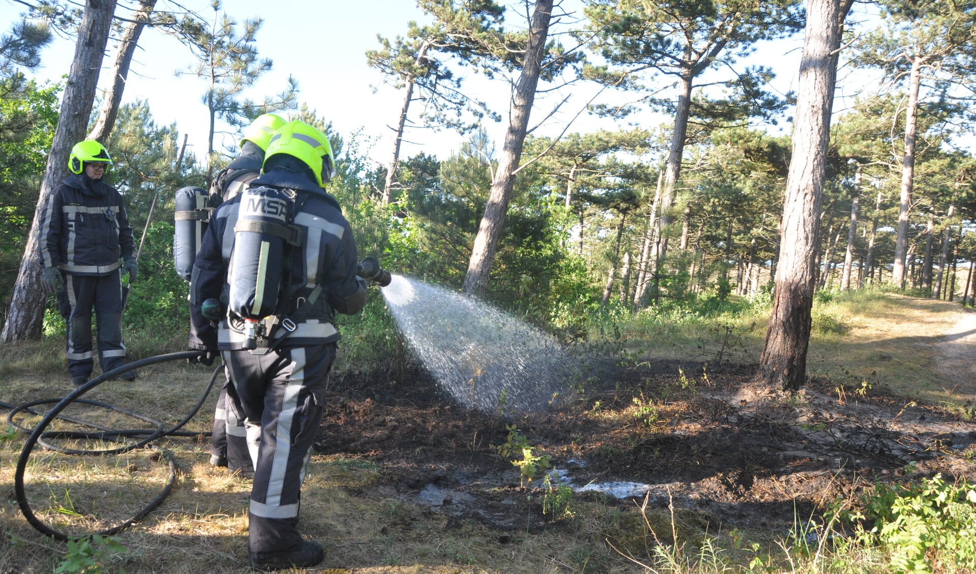 De brandweer in actie in het bos bij paal 21.