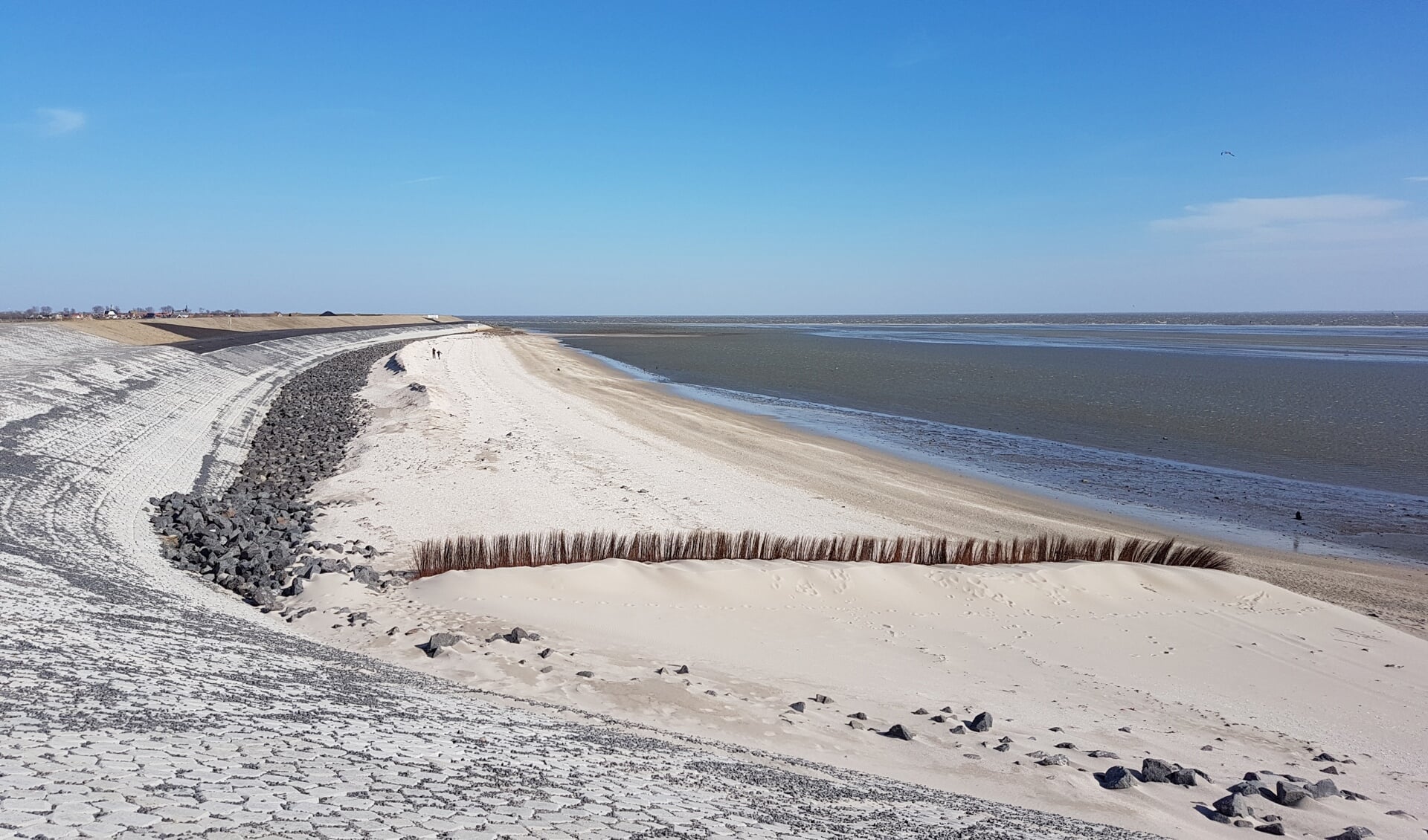 Een rietscherm dat recent op Ceres werd geplaatst. Volgens het hoogheemraadschap heeft aannemer Ooms ze geplaatst in verband met de harde wind van de afgelopen dagen. “Er stonden altijd al schermen, nu zijn er nieuwe geplaatst, dit doen ze altijd als er oostenwind wordt voorspeld. Want anders waait er zand over de dijk/op de dijk. Niets in relatie tot het project Prins Hendrikzanddijk dus.”