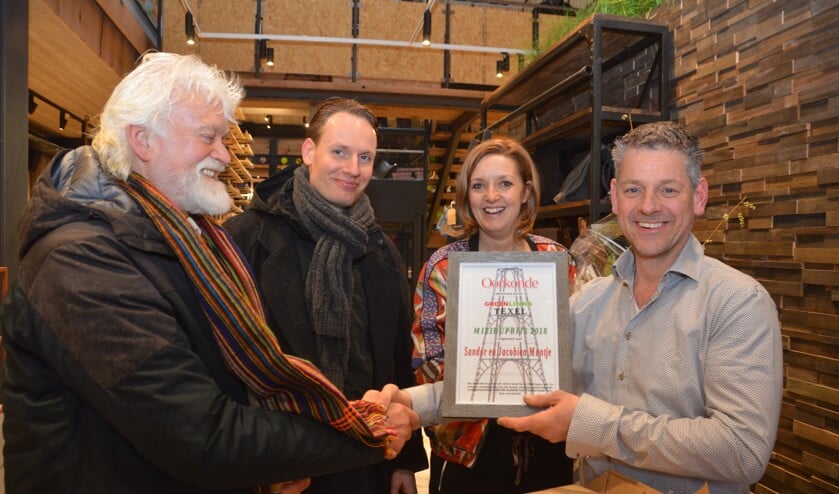 Jaap Vlaming en Sander van Knippenberg overhandigen de Groen Links Milieuprijs aan Sandor en Jacobine Mantje bij de opening van hun nieuwe winkel in De Koog.