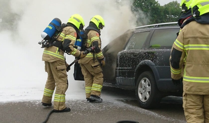 Brandweerlieden blussen de autobrand.
Foto Inter Visual Studio / Marcel Winter